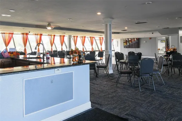 a living room with furniture a flat screen tv and kitchen view