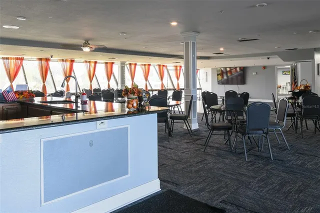 a living room with furniture a flat screen tv and kitchen view