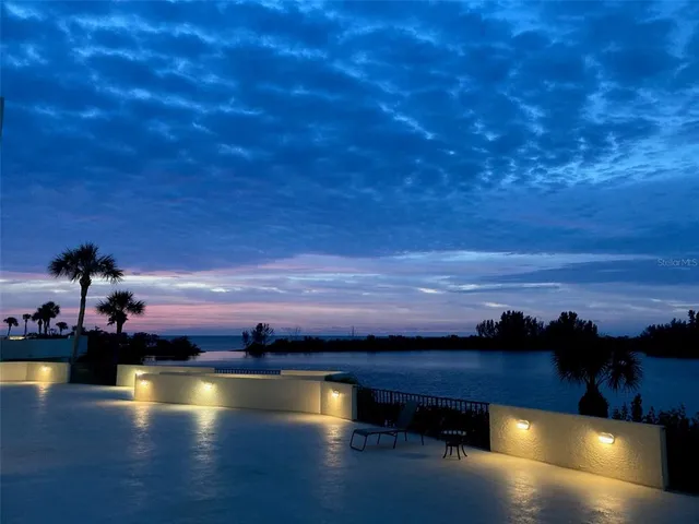 a view of a swimming pool with outdoor seating and lake view