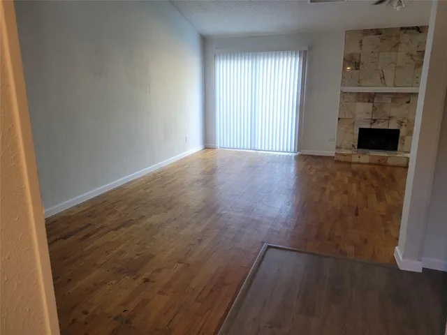 an empty room with wooden floor and a fireplace