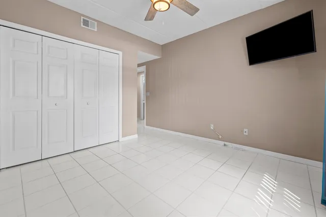a view of an empty room with a tv and a potted plant
