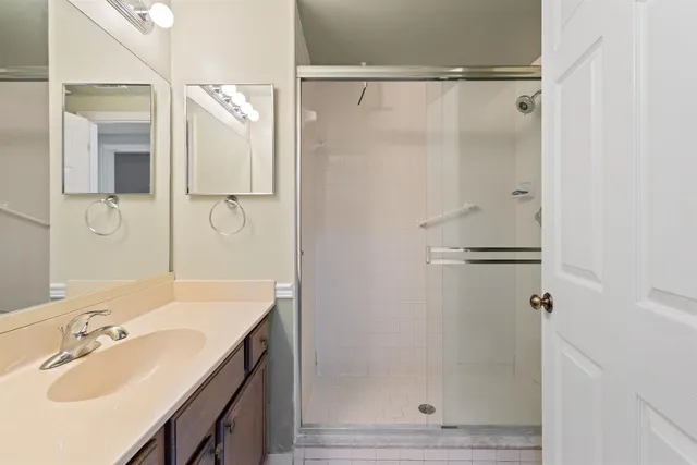 a bathroom with a shower sink and mirror