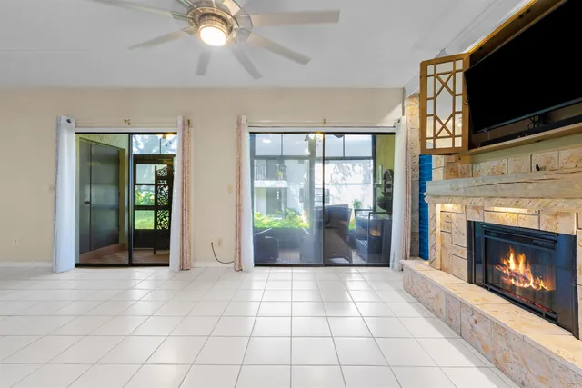 a view of an empty room with window and fire place