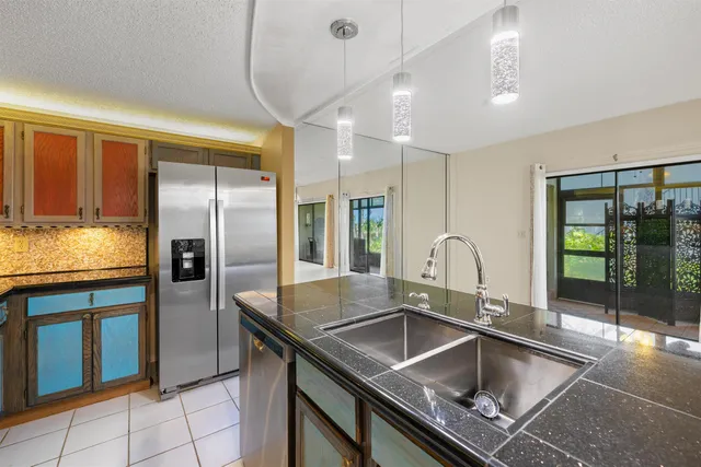 a kitchen with kitchen island granite countertop a sink stainless steel appliances and cabinets
