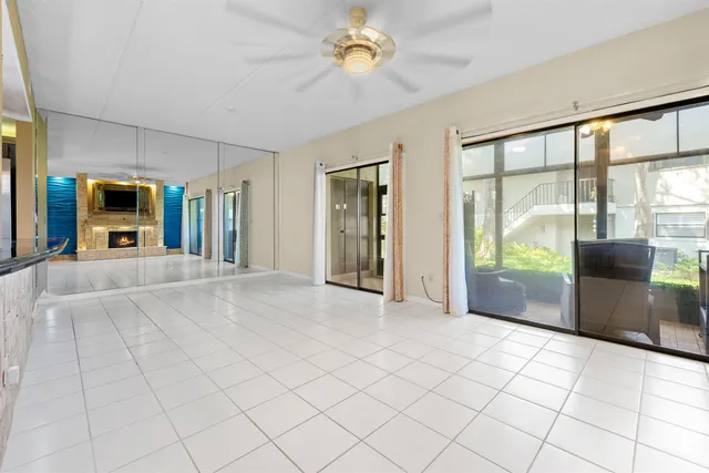 a view of a livingroom with a chandelier fan and windows