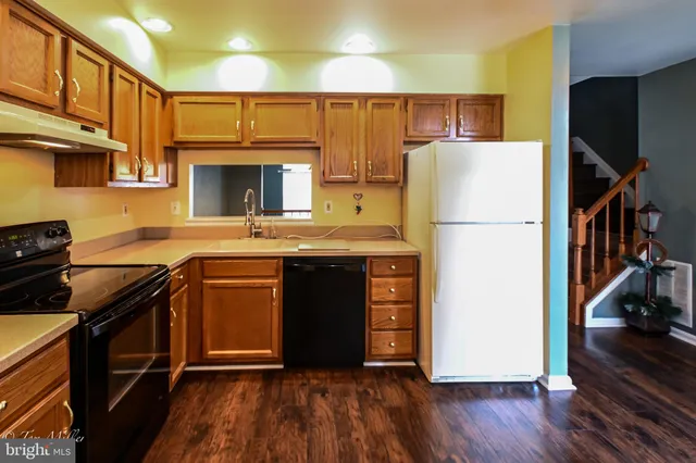 a kitchen with stainless steel appliances granite countertop a stove a sink and a refrigerator