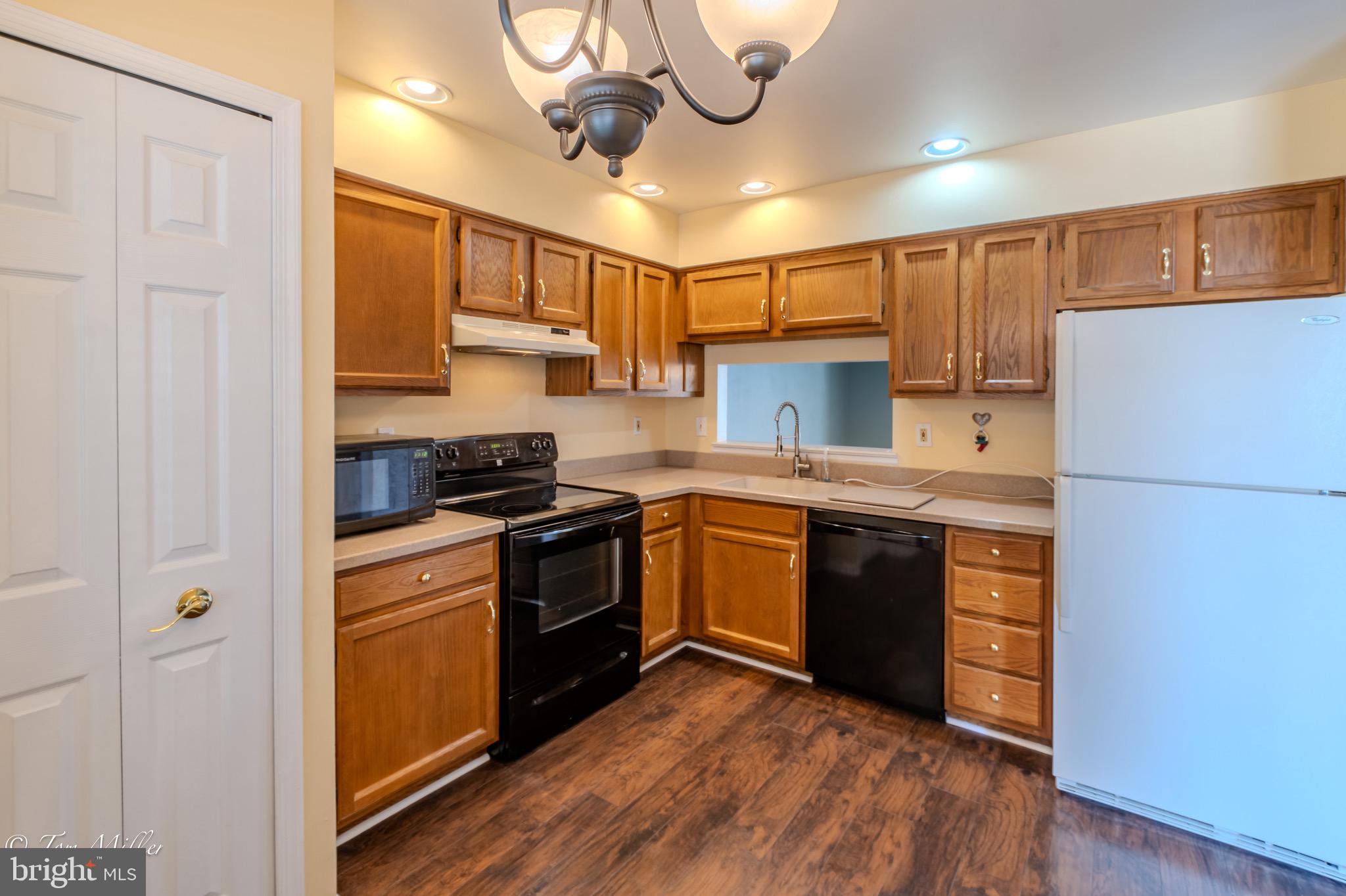 3721 Foxford Stream Road Nottingham, MD 21236 - Photo 13 of 48 a kitchen with stainless steel appliances granite countertop a refrigerator a sink dishwasher a stove and white cabinets with wooden floor