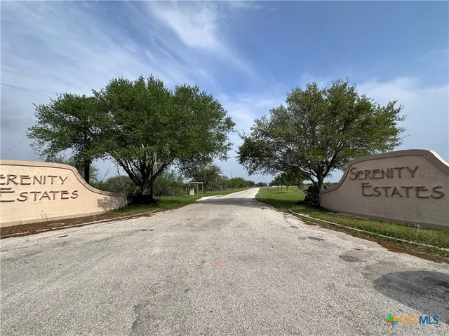 a view of a sign board with large tree