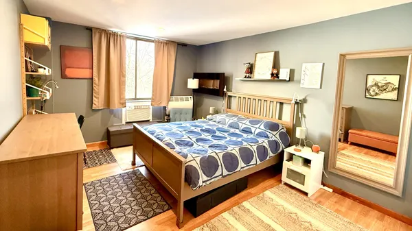 a bedroom with a bed and wooden floor