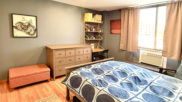 a bedroom with a bed and wooden floor