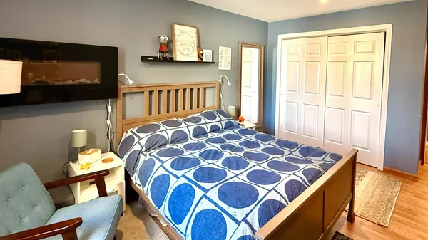 a bedroom with a bed and wooden floor