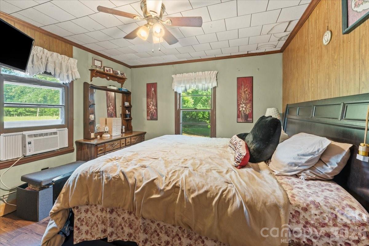 12282 Coyle Road Stanfield, NC 28163 - Photo 9 of 24 a bedroom with a bed and a chandelier