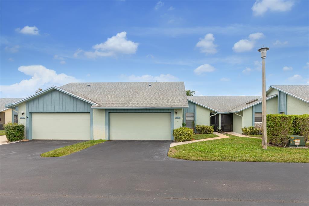 a view of a white house with a yard and potted plants