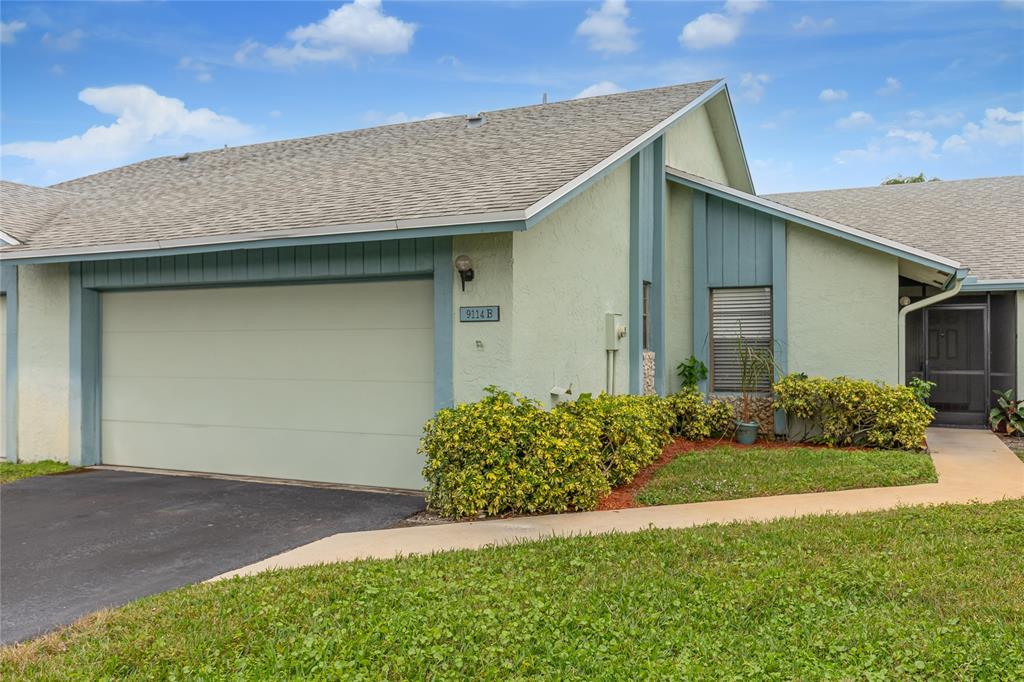 9114 Southwest 20th Street, Unit B Boca Raton, FL 33428 - Photo 2 of 36 a front view of house with yard and green space
