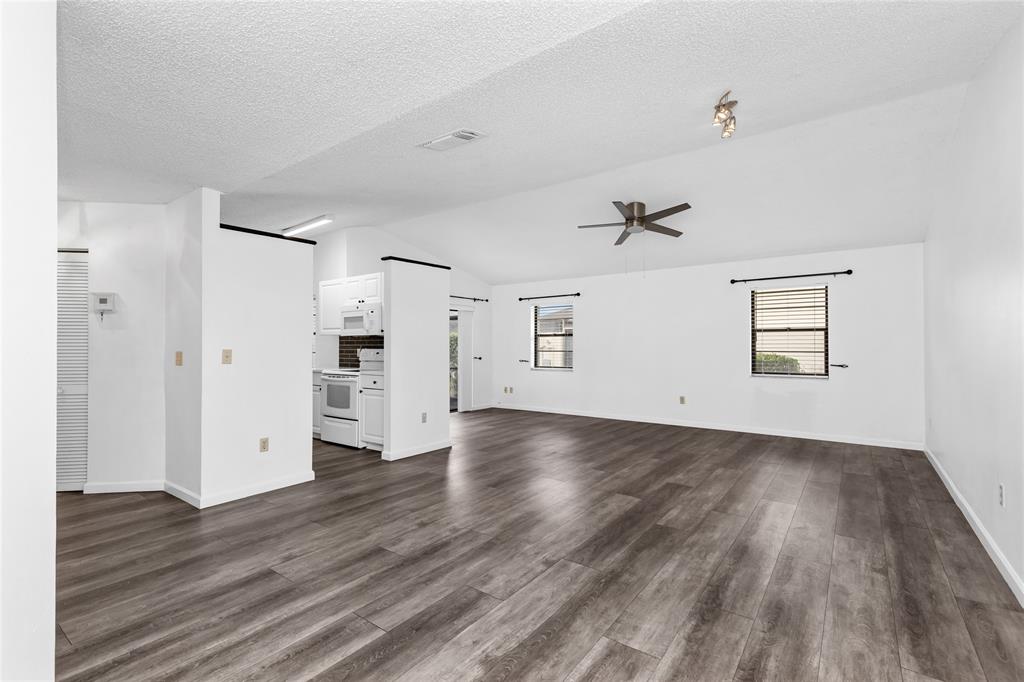 9114 Southwest 20th Street, Unit B Boca Raton, FL 33428 - Photo 9 of 36 an empty room with wooden floor and windows