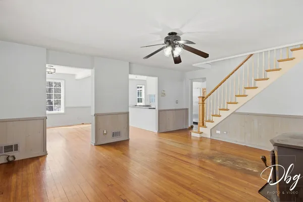 a kitchen with stainless steel appliances kitchen island granite countertop a table chairs in it and white cabinets