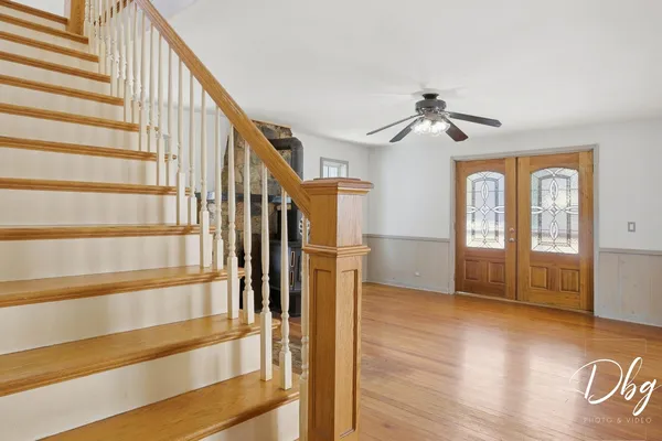 a view of a livingroom with wooden floor and a ceiling fan