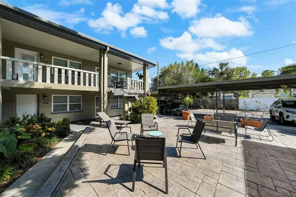 a view of a patio with couches table and chairs and potted plants