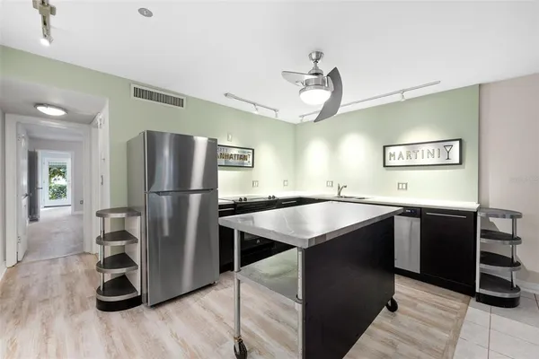 a kitchen with kitchen island a counter top space and stainless steel appliances