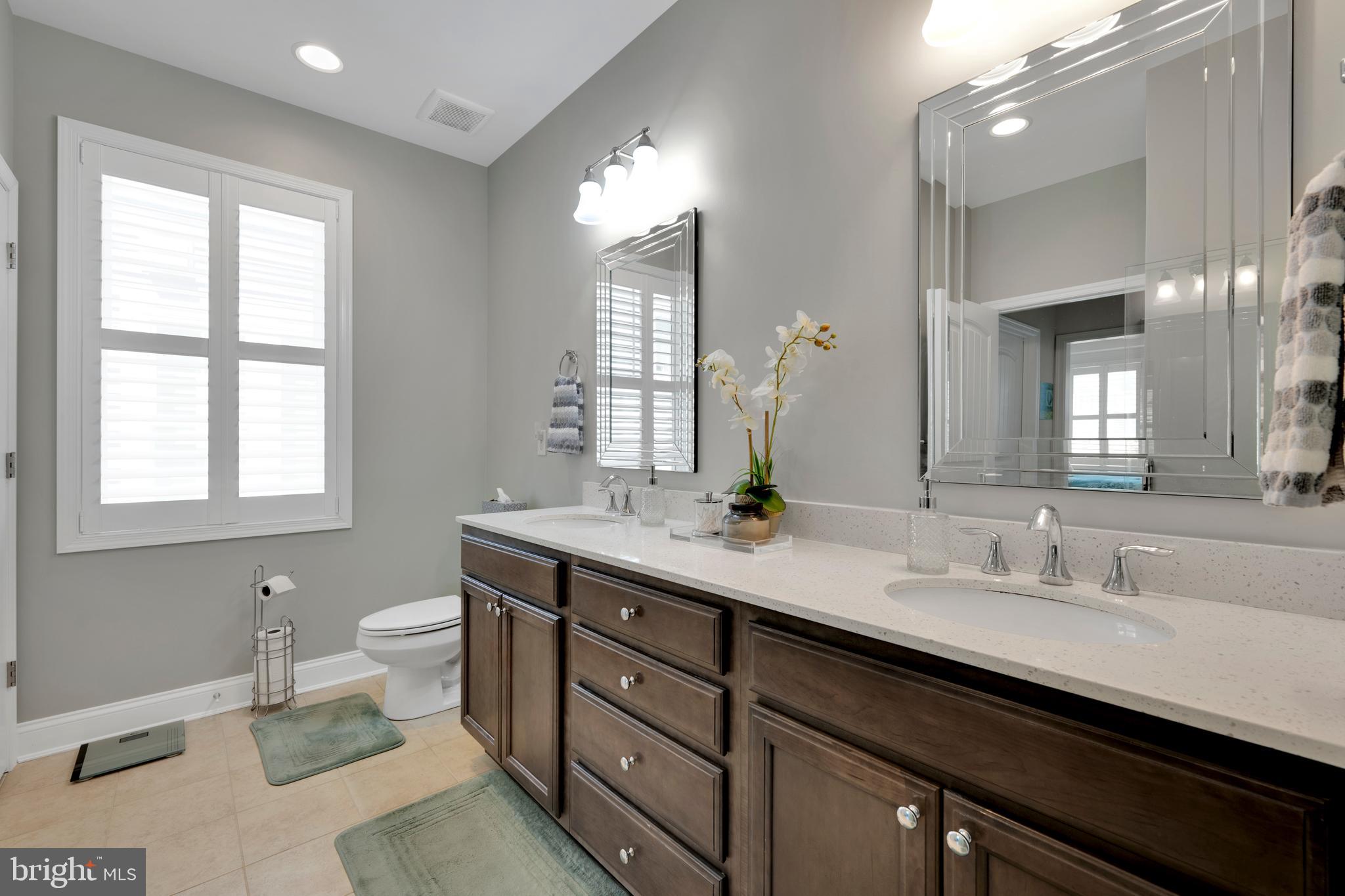 11886 Haslet Road Lewes, DE 19958 - Photo 25 of 60 a bathroom with a double vanity sink toilet and a mirror