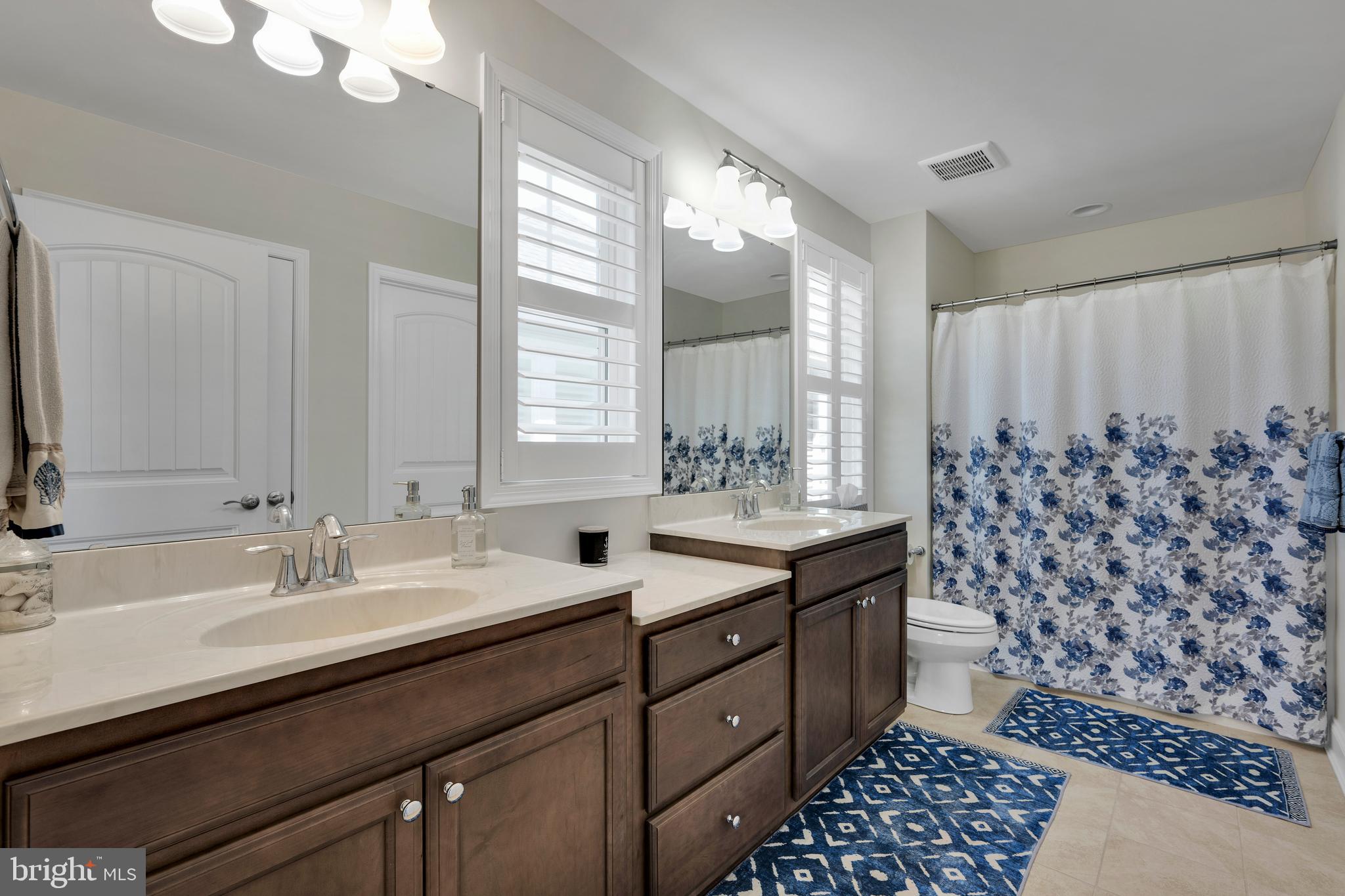 11886 Haslet Road Lewes, DE 19958 - Photo 34 of 60 a bathroom with a double vanity sink toilet and a mirror