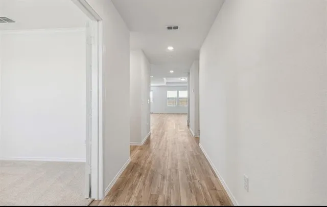 a view of a hallway with wooden floor