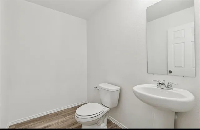 a bathroom with a sink a toilet and mirror