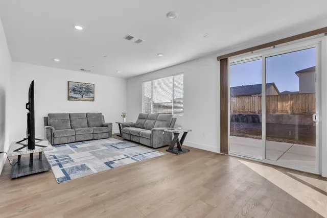 a kitchen with a refrigerator a stove a sink a dining table and chairs