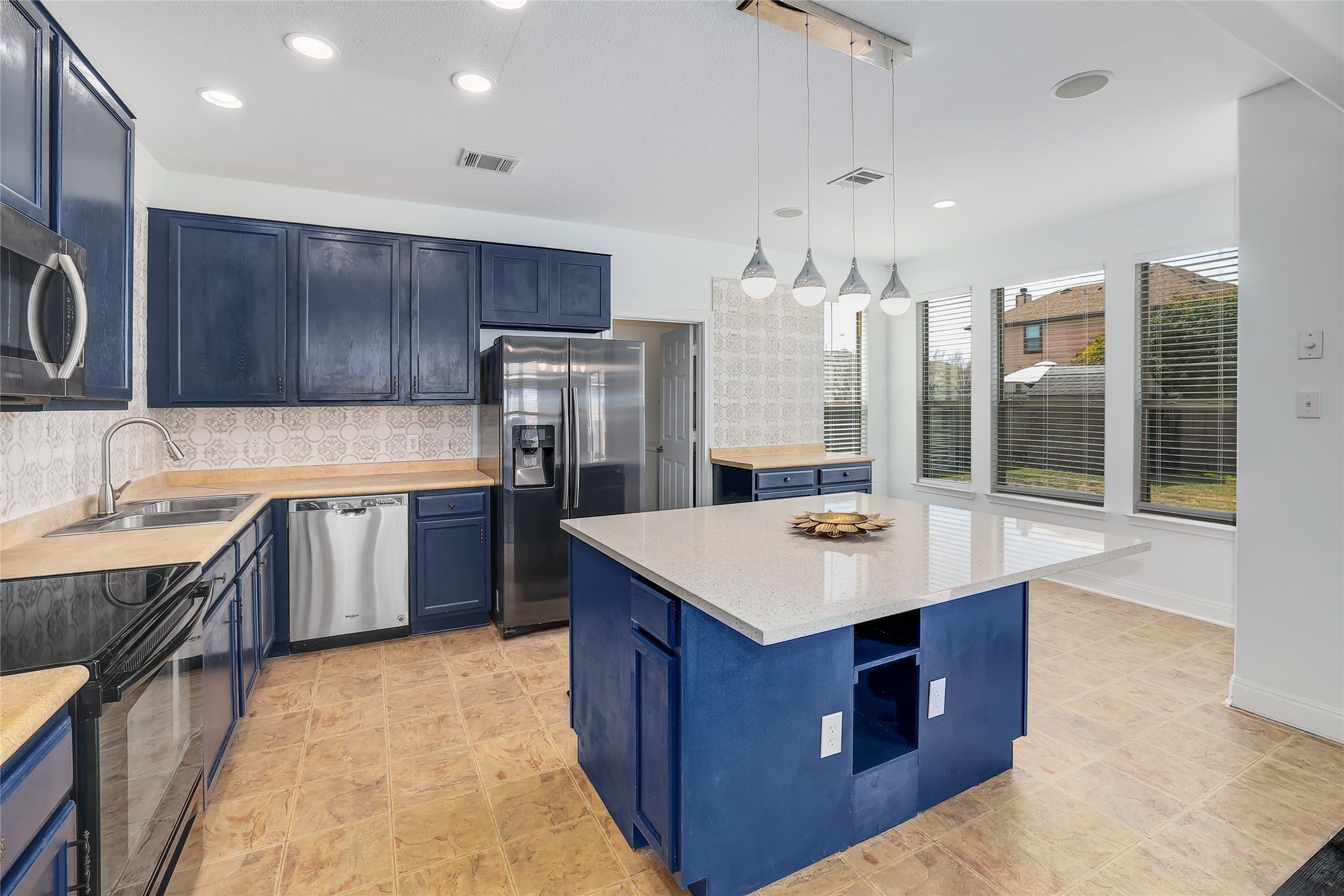 203 Ran Road Leander, TX 78641 - Photo 3 of 31 Gleaming stone countertops and matching cabinetry surround a central prep island in this kitchen.