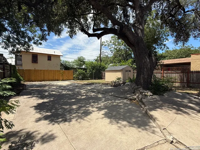 a view of a house with backyard and a tree