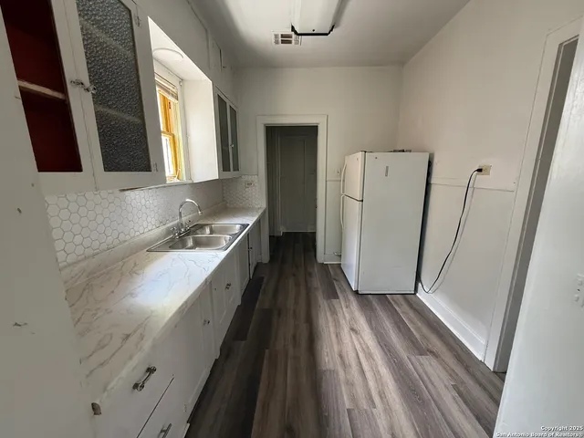 a bathroom with a granite countertop double vanity sink and a mirror
