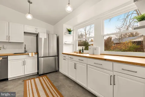 a kitchen with white cabinets and white appliances