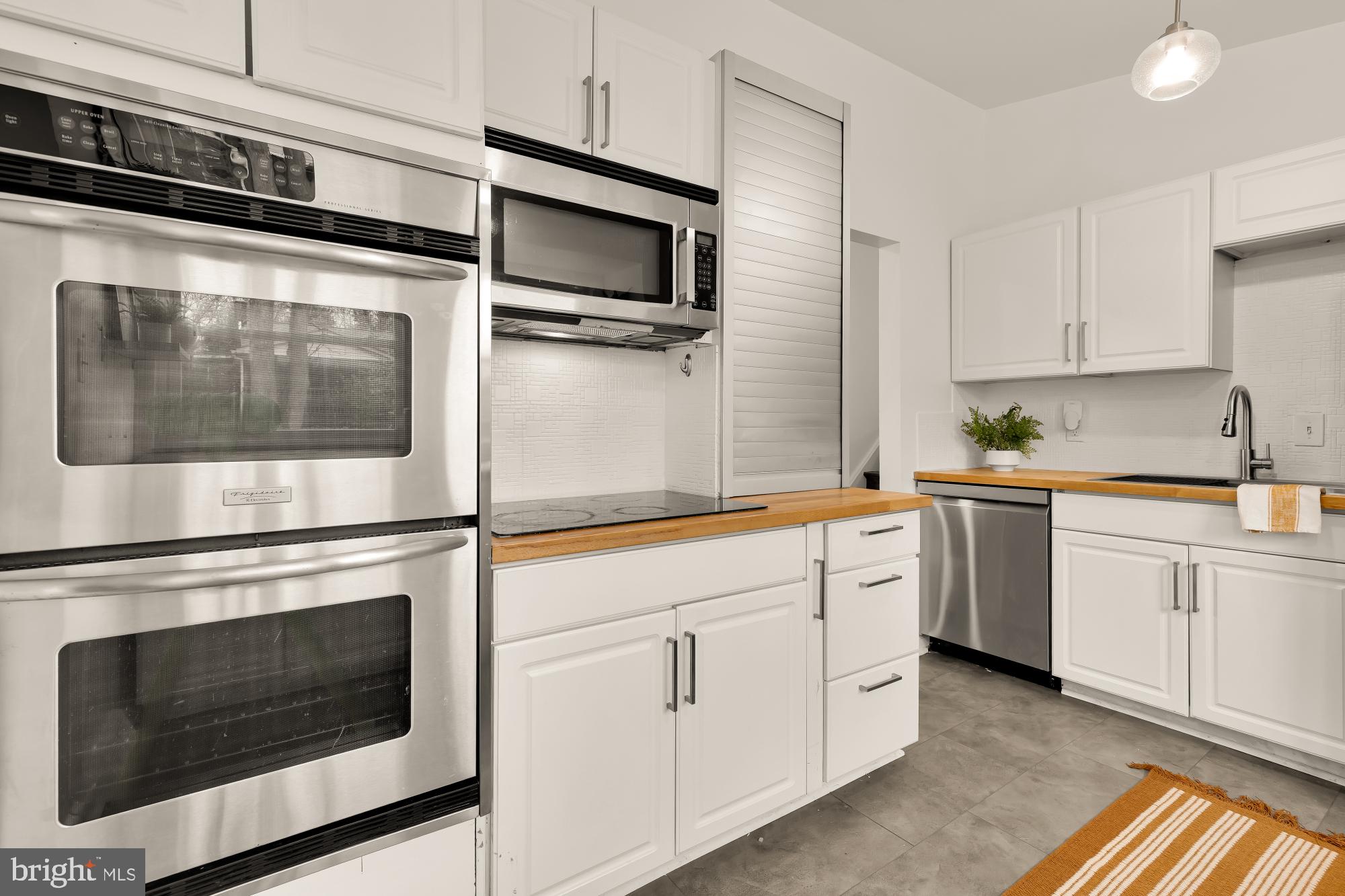 405 Irwin Street Silver Spring, MD 20901 - Photo 12 of 39 a kitchen with white cabinets stainless steel appliances and sink