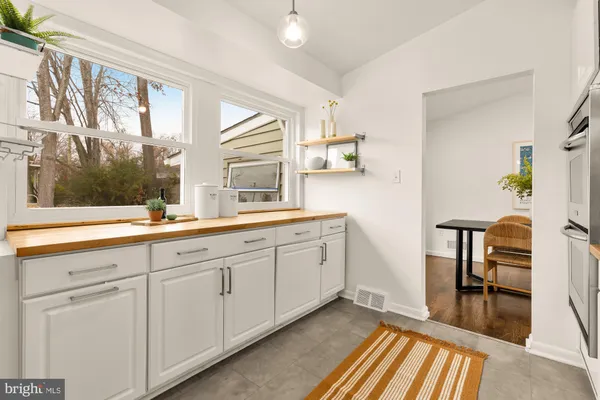 a spacious bathroom with a sink and a large mirror next to a window
