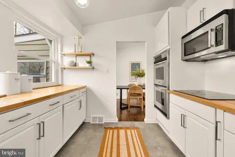 a kitchen with stainless steel appliances white cabinets and a window