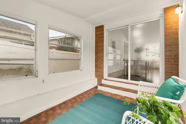 a living room with a floor to ceiling window and wooden floor