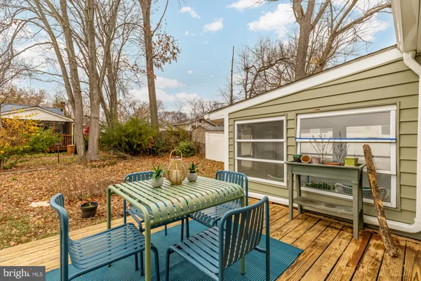a balcony with table and chairs with wooden floor and fence