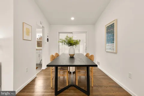 a dining room with furniture potted plants and wooden floor
