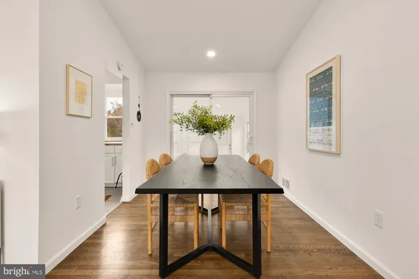 a dining room with furniture potted plants and wooden floor