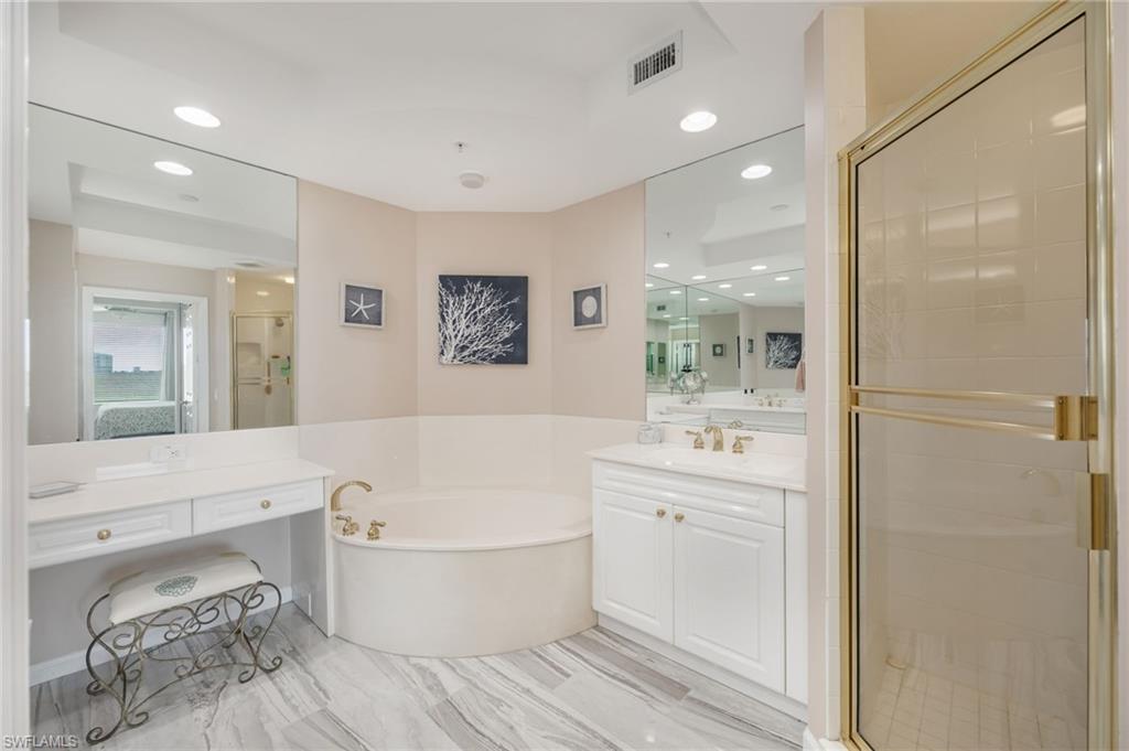 425 Cove Tower Drive, Unit 502 Naples, FL 34110 - Photo 11 of 18 a bathroom with a bathtub a sink and a mirror