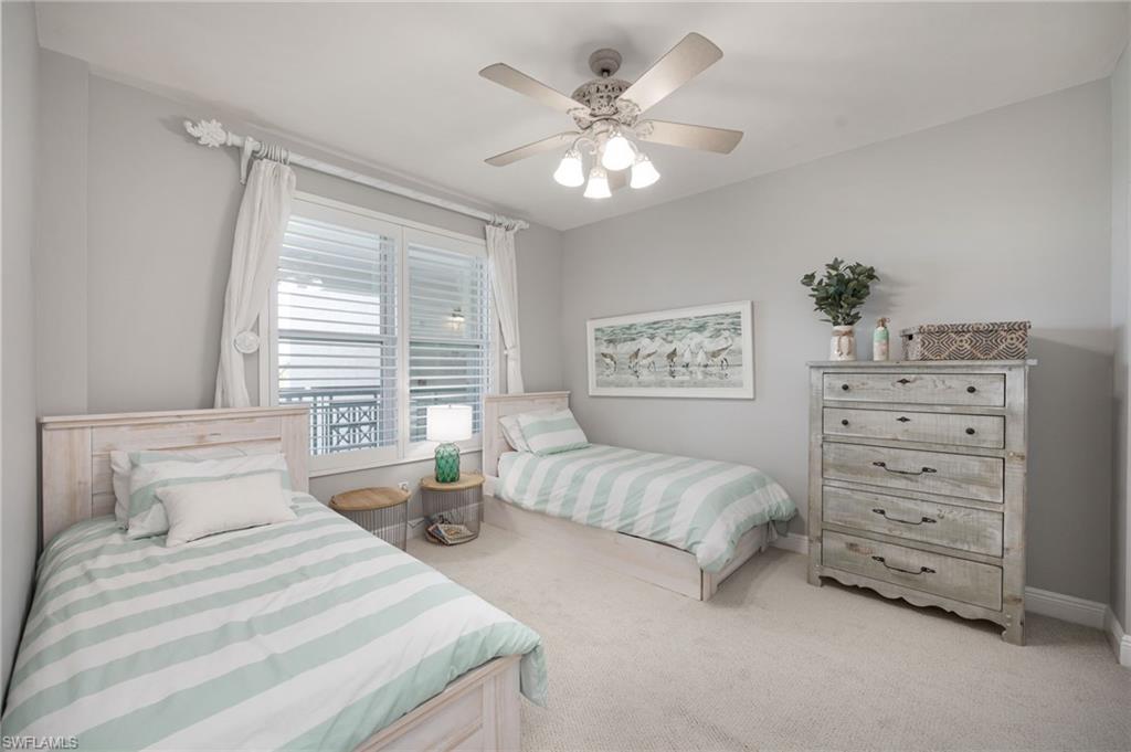 425 Cove Tower Drive, Unit 502 Naples, FL 34110 - Photo 12 of 18 a bedroom with a bed and a chandelier