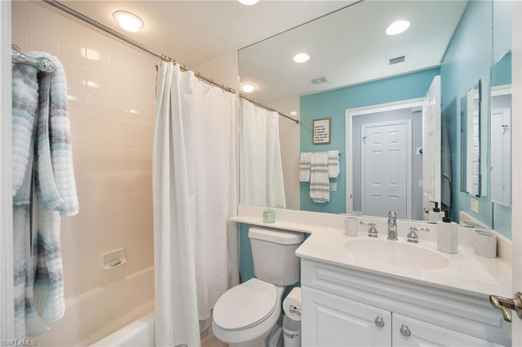 425 Cove Tower Drive, Unit 502 Naples, FL 34110 - Photo 13 of 18 a bathroom with a sink a toilet a mirror and shower
