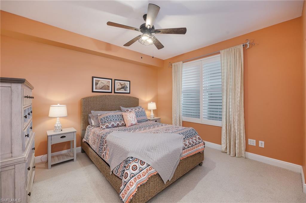 425 Cove Tower Drive, Unit 502 Naples, FL 34110 - Photo 14 of 18 a bedroom with a bed and a ceiling fan