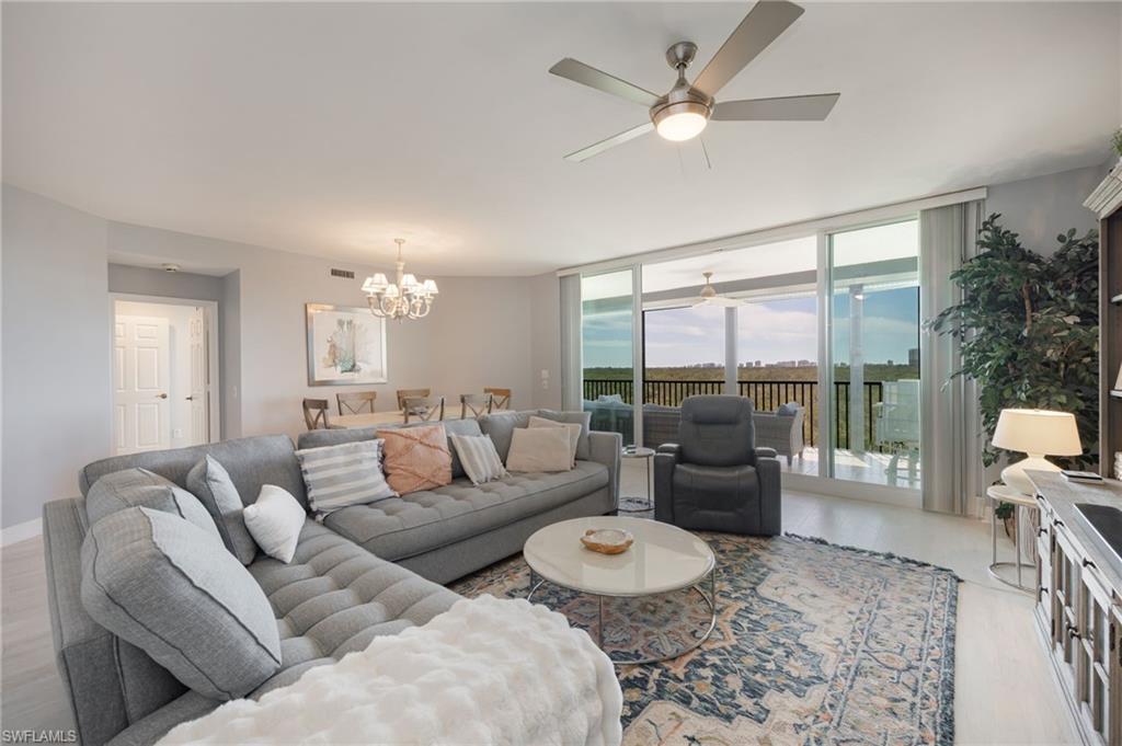425 Cove Tower Drive, Unit 502 Naples, FL 34110 - Photo 3 of 18 a living room with furniture and a large window with garden view