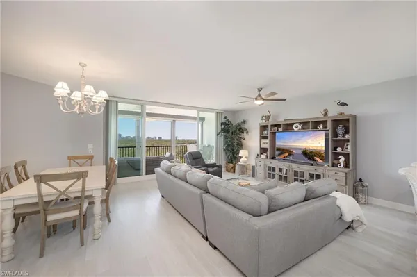a living room with furniture chandelier and a flat screen tv