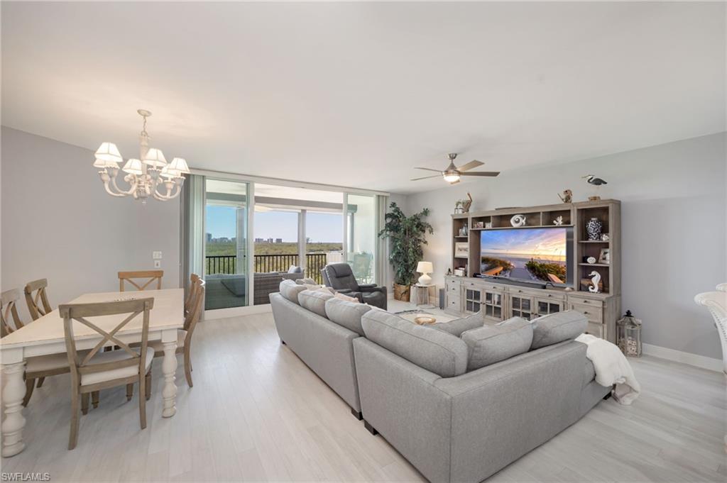 425 Cove Tower Drive, Unit 502 Naples, FL 34110 - Photo 5 of 18 a living room with furniture chandelier and a flat screen tv