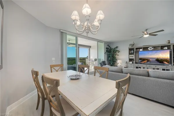 a view of a dining room with furniture a livingroom and chandelier