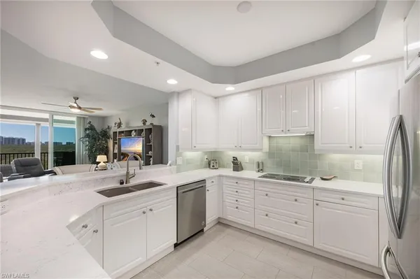 a kitchen with sink refrigerator and cabinets