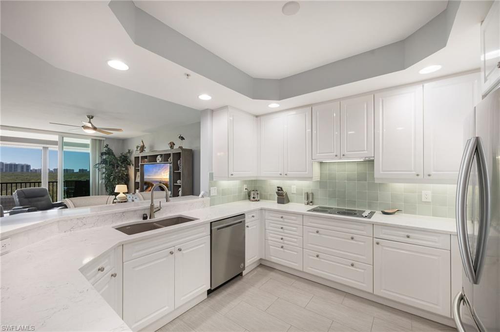 425 Cove Tower Drive, Unit 502 Naples, FL 34110 - Photo 8 of 18 a kitchen with sink refrigerator and cabinets