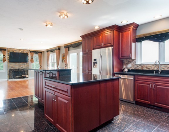 129 Raffaele Drive Waltham, MA 02452 - Photo 2 of 20 a kitchen with stainless steel appliances wooden cabinets a stove a sink and a refrigerator